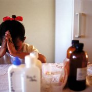 A nine-year-old girl in Johannesburg prays before taking her antiretroviral HIV-AIDS drugs.
